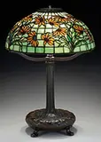 Black-Eyed Susan Table Lamp by Tiffany Studios, Shade rests on a decorated Tiffany Studios bronze library base, sold Jun 2017
