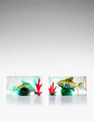 Two Aquarium Blocks by Ermanno Nason, for Vetreria Gino Cenedese, the solid glass block internally decorated with stylized fish and seaweed, sold Jun 2021