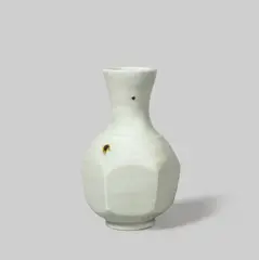 Small vase by Bernard Leach, circa 1963, Porcelain, celadon glaze with speckles, the body with broad cutsided facets, sold Dec 2021