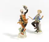 Harlekin mit Kanne und Harlekin mit Klatsche aus der Commedia dell'Arte by Meissen, 20. Jh, Porzellan, farbig und gold staffiert, sold Nov 2022