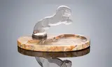 A 'Cinq Chevaux' Car Mascot, designed in 1922 by René Lalique, the glass of amethsyt hue, mould-blown, frosted and polished, and in a silvered metal mount on an oval striated marble b, offered Feb 2019