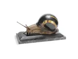 Ennio Tomai, A Large Figure of a Snail, circa 1920, patinated bronze, modelled as a moving snail with a striped shell, and mounted on a striated black marble plinth