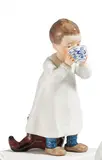 Stehendes Kind, aus einer Zwiebelmustertasse trinkend by Meissen, Frühe Ausformung vor 1924, Porzellan, farbig dekoriert, sold Nov 2022