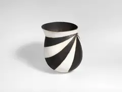 A Geometric Pattern Vase by John Ward, circa 1990, stoneware, of rounded form with an angled collar, matt black and white glaze alternating tapering panels over a softly t, sold Jun 2018