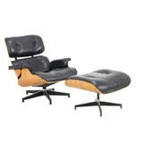 Charles and Ray Eames, LOUNGE CHAIR AND OTTOMAN FOR HERMAN MILLER, Upholstered in black leather with veneered, moulded ply shell on aluminium star swivel base. Manufacturer sticker present to underside