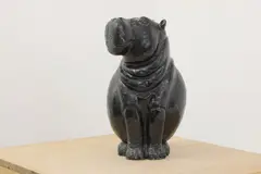 Phanuel Chakuda, Untitled, b.1953) Hippopatamus carved in black serpentine on an associated white marble plinth