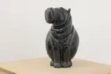Phanuel Chakuda, Untitled, b.1953) Hippopatamus carved in black serpentine on an associated white marble plinth