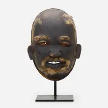 Lipiko mask by Makonde, carved and painted wood with applied hair, sold Feb 2021