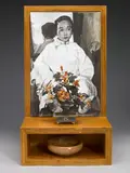 Hung Liu, Anonymous Woman, 1991, oil on canvas, laminated wood, Chinese polished hardstone tree in a cloisonne jardiniere, and a wooden bowl