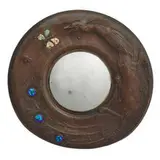 Arts & Crafts, convex mirror within a frame having repoussé peacock, butterfly and bee motif