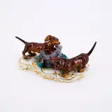 Meissen, Zwei Dackel, mit einem Hut spielend, 1901-1924, Porzellan, polychrom und gold staffiert