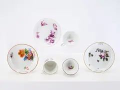Zwei Tassen, Koppchen und drei Untertassen by Meissen, Porzellan, polychrom staffiert, Camaieumalerei in Purpur, Goldrand., sold May 2026