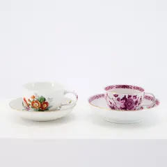 Zwei Tassen mit Untertassen mit unterschiedlichen Dekoren by Meissen, Porzellan, polychrom und dezent gold staffiert, Camaieumalerei in Purpur., sold May 2026