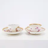 Meissen, Zwei Tassen mit Untertassen mit Camaieumalerei, Porzellan, Camaieumalerei in Purpur, gold staffiert.