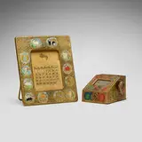 Zodiac picture frame and mechanical address file by Tiffany Studios, c. 1915, acid-etched, gilt, and polychromed bronze, printed card stock, sold Jul 2024