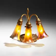 Three-light Lily desk lamp by Tiffany Studios, c. 1910, acid-etched gilt bronze, hand-blown Favrile glass, sold Jul 2024
