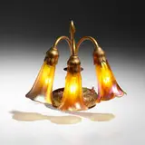 Three-light Lily desk lamp by Tiffany Studios, c. 1910, acid-etched gilt bronze, hand-blown Favrile glass, sold Jul 2024