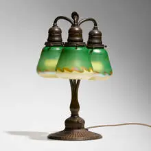 Three-arm table lamp by Tiffany Studios, c. 1910, patinated bronze, hand-blown Favrile glass, sold Jul 2024