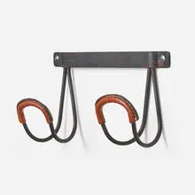 Coat rack by Jacques Adnet, c. 1965, saddle-stitched leather over enameled steel, sold Jun 2024