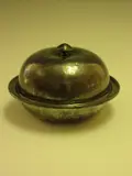 Liberty & Co., A 'Tudric' beaten pewter muffin dish, cover and liner,