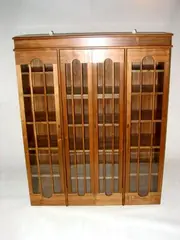 Alan Peters Obe, A walnut and sycamore lined Bookcase, fitted with four arched glazed doors,