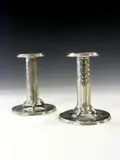 A pair of 'Tudric' polished pewter candlesticks, by Liberty & Co., A pair of 'Tudric' polished pewter candlesticks,, offered May 2004