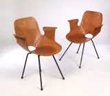 Vittorio Nobili, A pair of chairs manufactured by Medea, single piece plywood shell veneered in opposing walnut veneer, on black laquered rod supports with rubber feet (2)