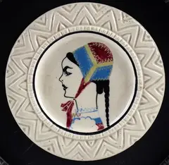 Plate with decoration of young woman in Desulo costume by Federico Melis, Lot includes a contemporary frame. Signed on the back: S.C.I.G., offered Feb 2026