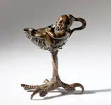 Andrea Riccio, Dwarf-shaped lamp on a bird of prey's leg, Bronze with reddish patina on black traces.