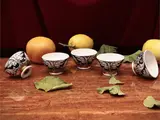 Series of five Snmalata ceramic aperitif cups by Piero Fornasetti, Decorated in black monochrome with golden highlights, offered Apr 2025