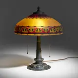 Table lamp with geometric border by Brass Pittsburgh Lamp & attribution Glass Co., c. 1920, patinated metal, obverse-painted textured glass, sold Mar 2024
