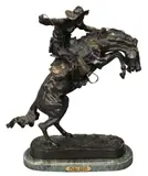 Frederic Remington, The Bronco Buster, Bronze on green marble base depicting a cowboy atop a rearing bronco