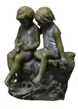Auguste Moreau, Two children holding a small bird and seated on a rock Cast, bronze in moss green patina