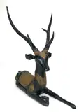 Recumbent Stag with Gilt Repousse Ornament by Sarreid Ltd, bronze and applied gilt brass repousse panels, offered May 2026