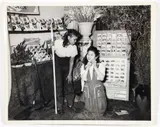 Charles Harris, (American/Pittsburgh, 1908-1998), Two women, one kneeling and one holding a rake, posing in garden display in front of Vegetable and Flower Seeds