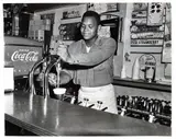 Charles Harris, (American/Pittsburgh, 1908-1998), Soda jerk at soda fountain with advertisements for Reymers Blennd, bulk ice cream, and Hot Nestle’s