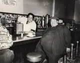 Teenie (American/Pittsburgh, 1908-1998), Man at the Lunch Counter in Pinstripe Suit, taken c. late 1940s, printed c.1980s, matte by Lawren Harris, photograph, offered Sep 2023