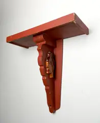 Elijah Pierce, hanging wall shelf, painted red and bas-relief carving of A Woman's Profile on each side, 1973, signed E. Pierce 1973 in, pencil verso