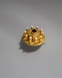 Brosche in Tortenform für Queen Victoria von England (1819–1901) zum zweiten Geburtstag ihrer Tochter Princess Royal Victoria (1840–1901) am 21. November 1842 by Prinz Albert von Sachsen-Coburg und Gotha, 1842, Gold, getrieben, ziselliert; Golddraht, gedreht; 10 Flussperlen, Granat. 2,3 cm; Ø 4,6 cm ( ⅞ in.; Ø 1 ¾ in.), sold May 2018