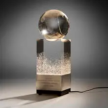 National Geographic Society Centennial Award trophy by James Houston for Steuben, 1988, acid-etched lead glass, silver, painted wood, sold Apr 2025