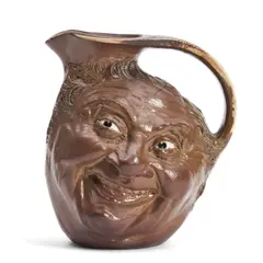 Robert Wallace Martin, for Martin Brothers Pottery Double Face Jug, 1903, brown glazed and with white eyes, incised signature and date to underside "R