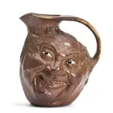 Robert Wallace Martin, for Martin Brothers Pottery Double Face Jug, 1903, brown glazed and with white eyes, incised signature and date to underside "R