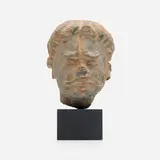 Head of a Bodhisattva by Possibly ancient region of Gandhara, grey schist, enameled metal, painted wood, sold Feb 2025