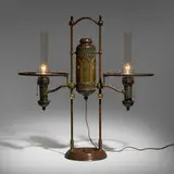 Double-arm student lamp base by Tiffany Studios, c. 1901, patinated bronze, sold May 2024