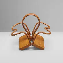 Bottle holder by Jacques Adnet, c. 1950, saddle-stitched leather over steel, oak, sold Apr 2024