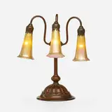 Three-light Lily table lamp base by Tiffany Studios, c. 1910, patinated bronze, sold Aug 2023