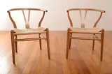 A SET OF FOUR CH24 WISHBONE CHAIRS by Hans J. Wegner, oak, papercord, sold Mar 2013