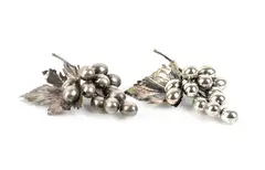 Nature Collection: a pair of silver bunches of grapes by Mario Buccellati, Each piece features a large embossed vine leaf with veins finely engraved using a burin, offered Sep 2026