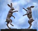 John Cox, Untitled, John Cox (b.1941) BOXING HARES Bronze with brown patina, on a reclaimed oak base 70cm wide 72cm high .