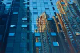 Mirrored reflections (skyscraper) by American School, oil on canvas, sold Jul 2023